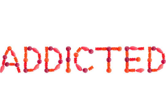 Word "ADDICTED" made of red sugary candies, isolated