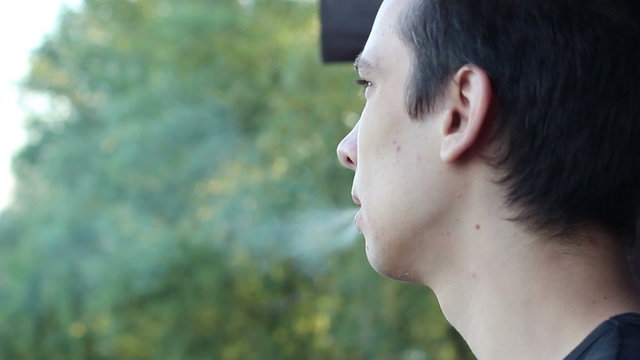 guy smokes and looks into the distance
