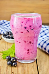 Milkshake with black currants and napkin on board