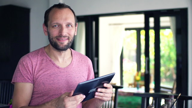 Happy man with tablet computer at home