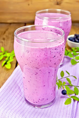 Milkshake with blueberries in glasses on board