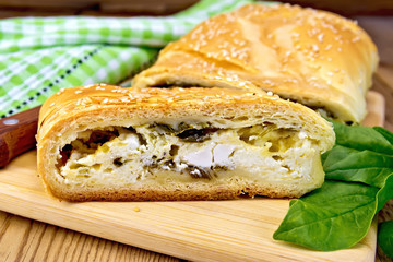 Roll filled with spinach and cheese on board