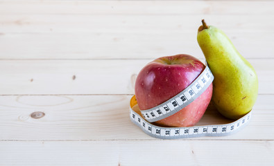 pear and apple  on the wooden background, shape of the body
