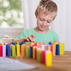 junge spielt mit domino-steinen