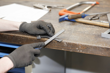 Auszubildender mit Metallwerkstück in der Gewerbeschule