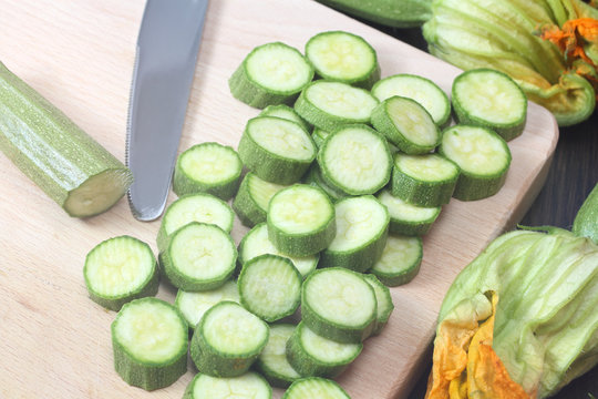 Sliced zucchini on wooden chopping board