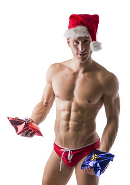 Muscular man in a speedo and Santa Claus hat