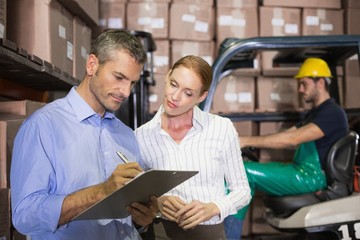Warehouse team working together with clipboard
