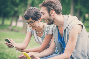 couple of friends young  man and woman using smartphone