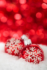 Fototapeta na wymiar Christmas balls with painted snowflakes against red holiday li