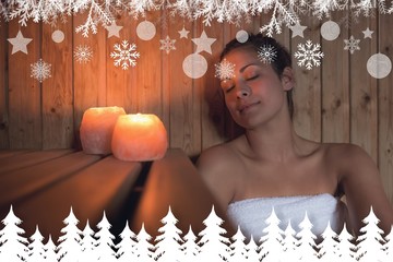 Obraz na płótnie Canvas Happy brunette woman sitting in a sauna
