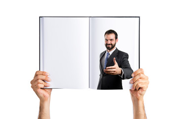 businessman making a deal printed on book