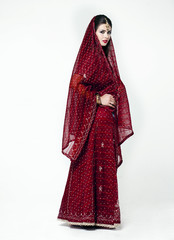 Naklejka premium Young pretty woman in indian red dress
