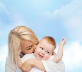 happy mother kissing smiling baby
