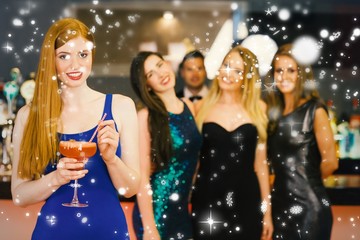 Woman holding cocktail standing in front of her friends