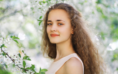 Naklejka premium Cute smiling girl outdoors, sunny spring portrait young girl
