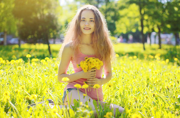 Sunny photo happy girl on yellow meadow with dandelions © rohappy