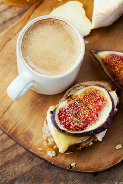 Breakfast setting with coffee, bread, cheese, figs and honey