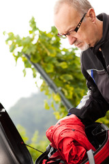 Motorradfahrer verstaut Regenschutz