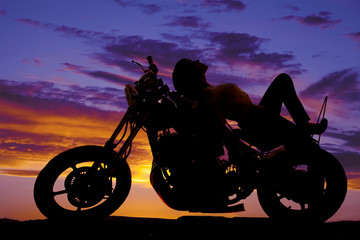 Fototapeta na wymiar woman silhouette on motorcycle lay on tank