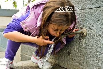 Obraz na płótnie Canvas Child drinking water from a fountain