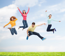 Fototapeta na wymiar group of smiling teenagers jumping in air