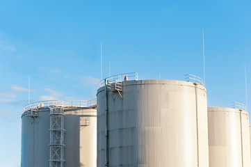 Three petrol tanks on blue sky background. Storage in Riga.