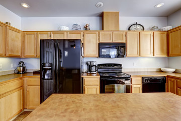 Light brown kitchen with black appliances