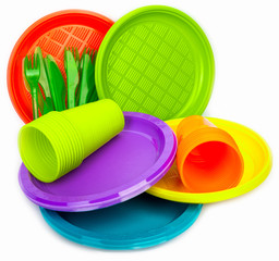 Disposable bright plastic dishes stacked on white