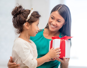 happy mother and child girl with gift box