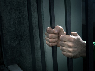 Man in jail hands close-up