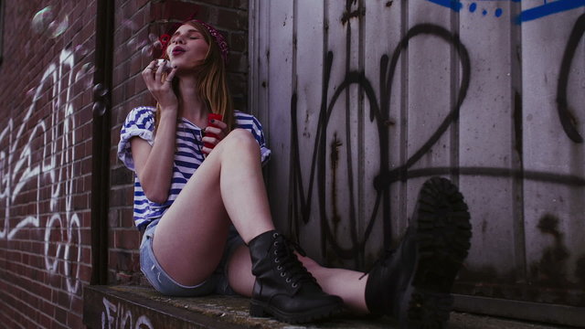 Hipster girl blowing bubbles in grunge urban area