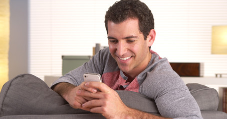 Fototapeta premium Man happily texting on smartphone