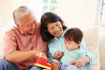 Obraz premium Grandparents And Grandson Playing With Toy Together