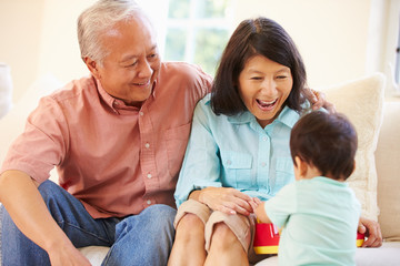 Grandparents And Grandson Playing With Toy Together