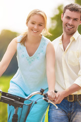 Obraz premium Happy Couple Having Fun Together Riding Bike Outdoors