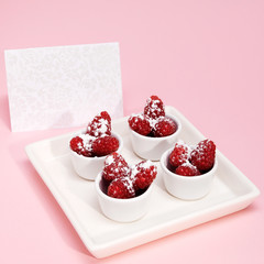 Raspberry with  sugar and an invitation card
