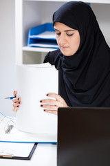 Muslim female office worker doing paperwork