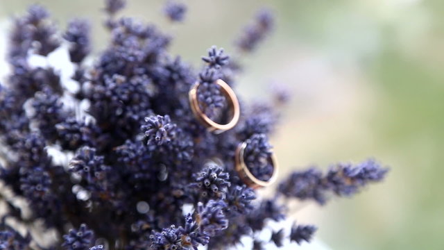 Two wedding rings on a bouquet of lavender.