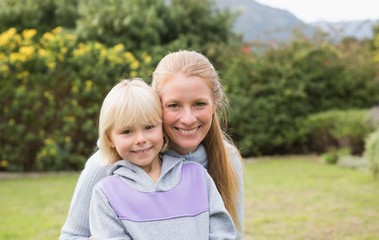 Cute daughter and mother smiling at camera