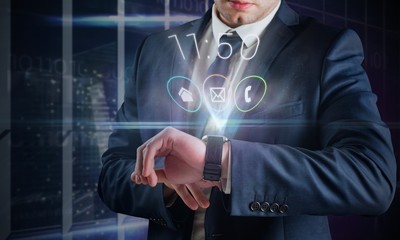 Composite image of businessman using hologram watch