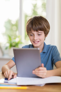 junge liest zuhause am tablet-pc