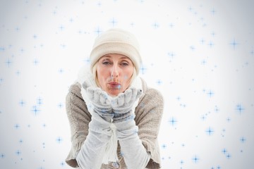 Mature woman in winter clothes blowing kiss