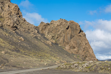 Track and rock hill through Iceland, blue sky