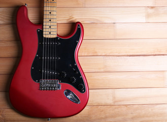 Fototapeta premium Red guitar on wooden background