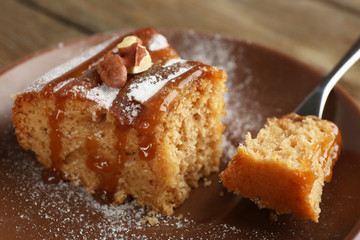 Half eaten delicious cake piece on plate on wooden table