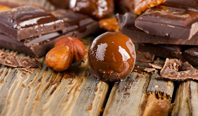 Chocolate candy   and nuts  on   wooden table