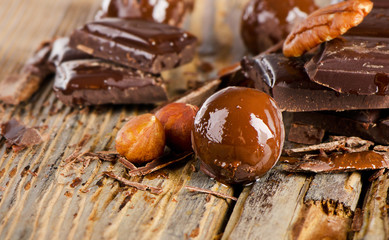Broken chocolate bar  and nuts  on  wooden table