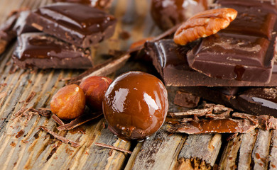 Chocolate bar  and nuts  on  a wooden table