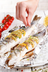 Tasty baked fish in foil on table close-up